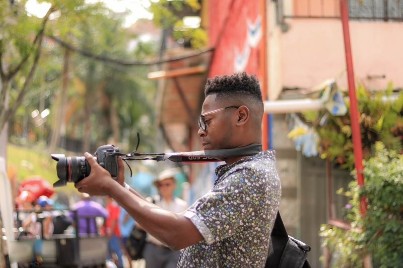Saulón Guerrero lining up a shot with a camera on a street